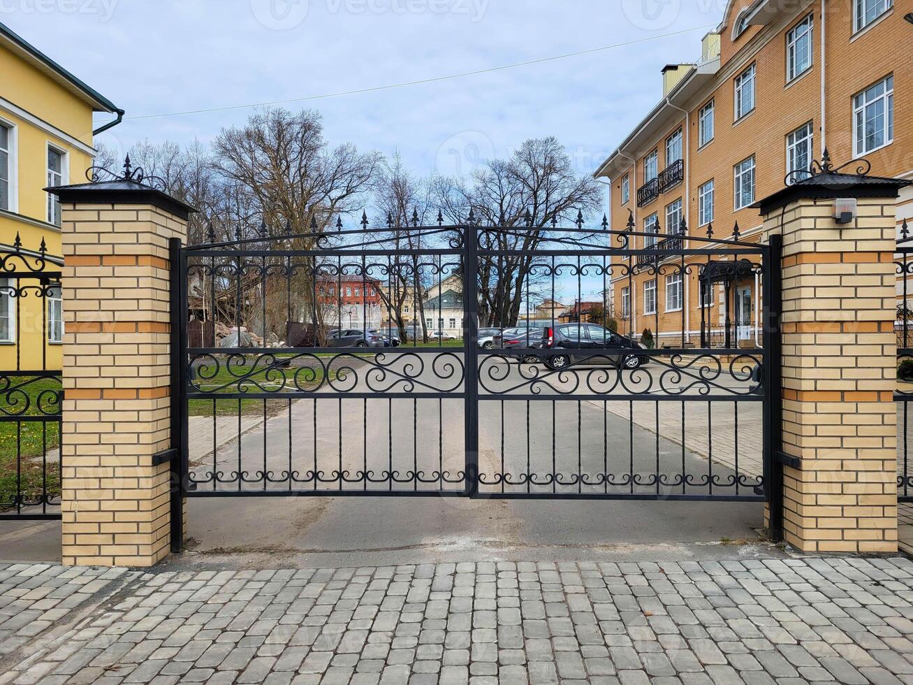 Beautiful new cast iron openwork gates on a cloudy autumn day photo