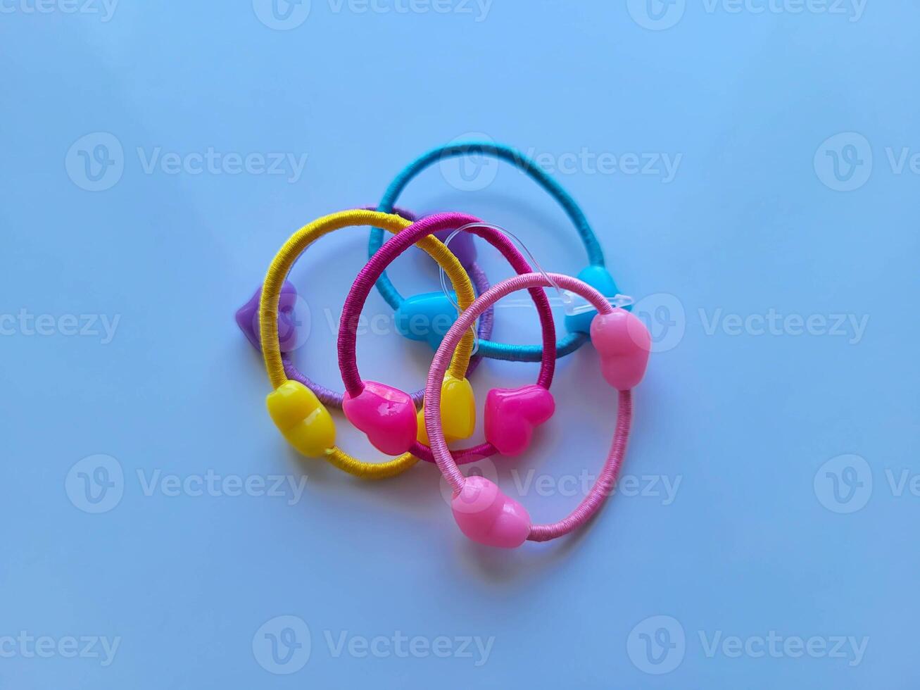 Colorful children's hair bands with hearts lie on a blue background. photo