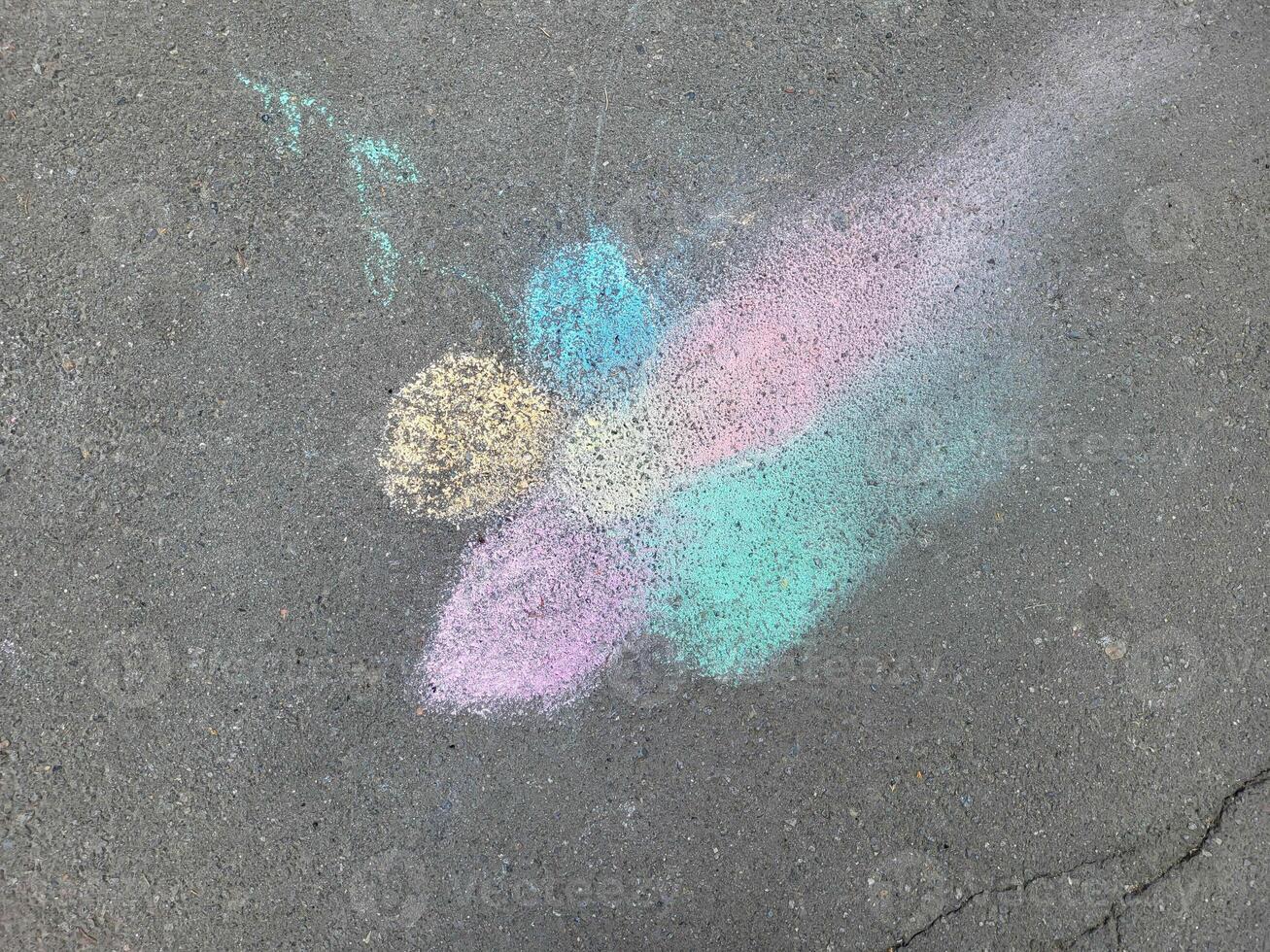 Multicolored drawing of a flower on asphalt in chalk. photo