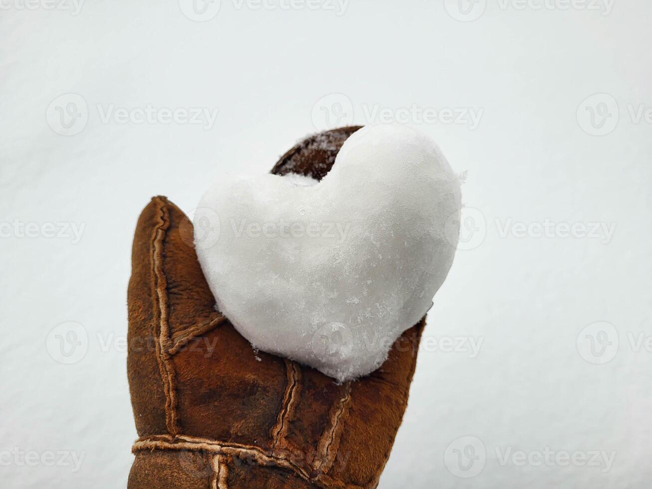 There is a snow heart on the mitten. The concept of love, romance, Valentine's Day, Christmas photo
