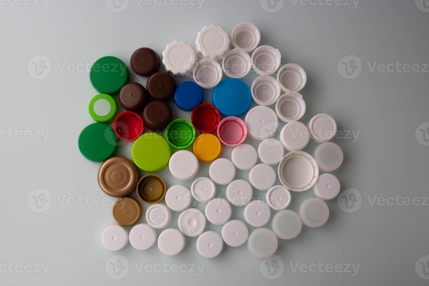 Colorful plastic lids from different drinks are on the table photo