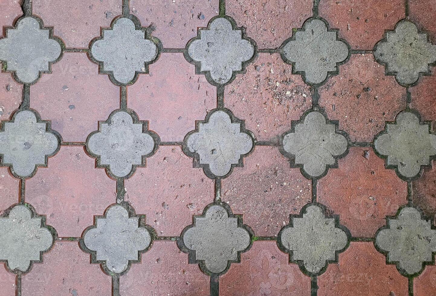 Wet red patterned paving slabs. Outdoor tile background. photo