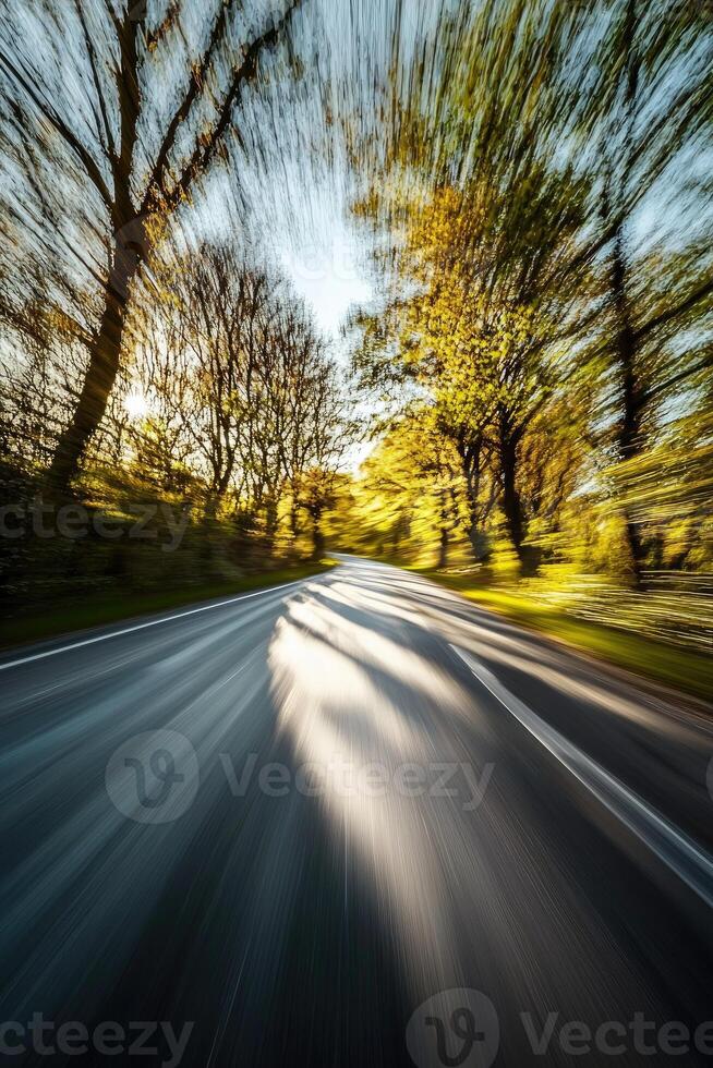 A fast drive through autumnal trees along a winding road photo