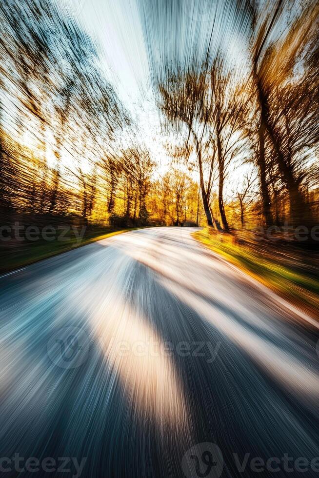A fast drive through autumn trees along a curving road photo