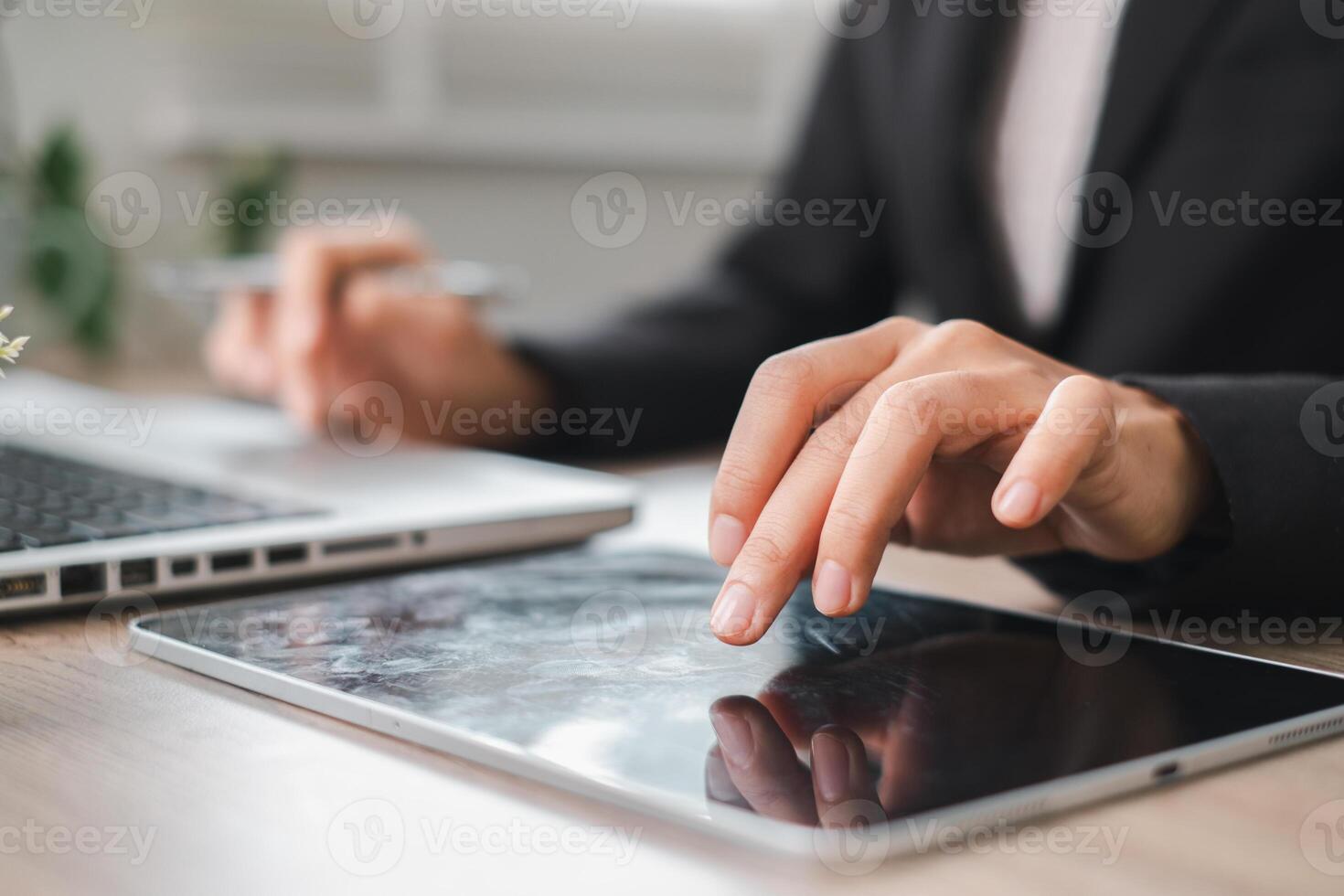 Close-up of hands using a tablet and laptop, symbolizing modern business technology and productivity. photo