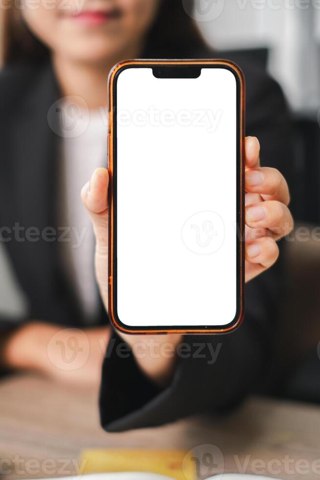 Businesswoman Holding Smartphone with Blank Screen for Mockup in Office Setting photo