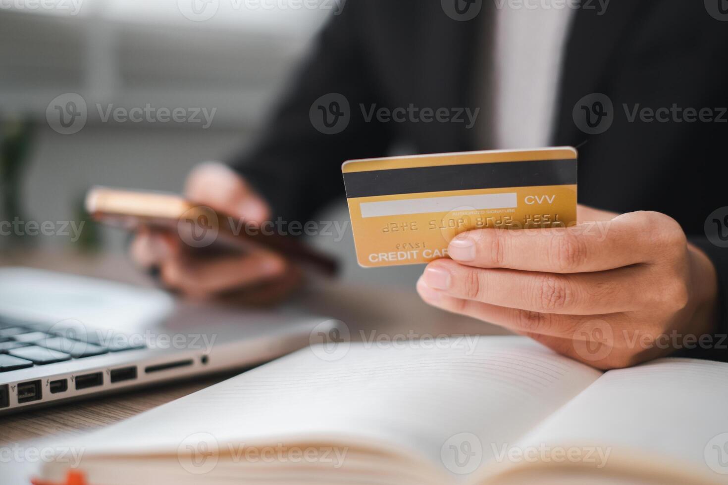 Business Professional Using Credit Card for Online Payment While Working on Financial Planning at Office Desk photo