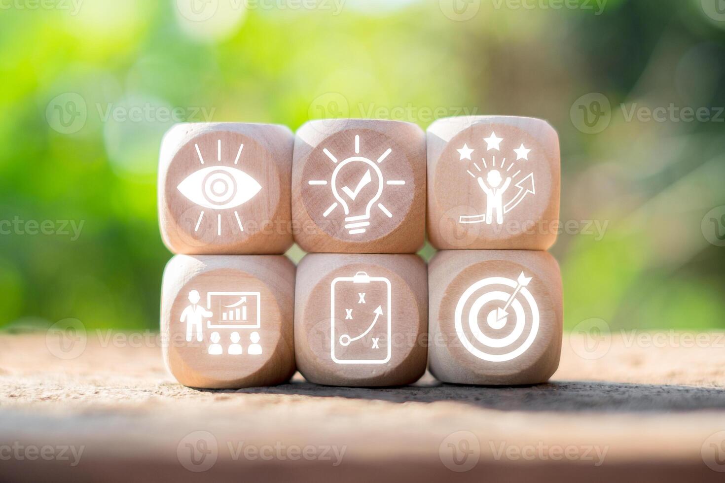 Wooden blocks with icons symbolizing personal growth, success, and development in a natural outdoor setting. photo