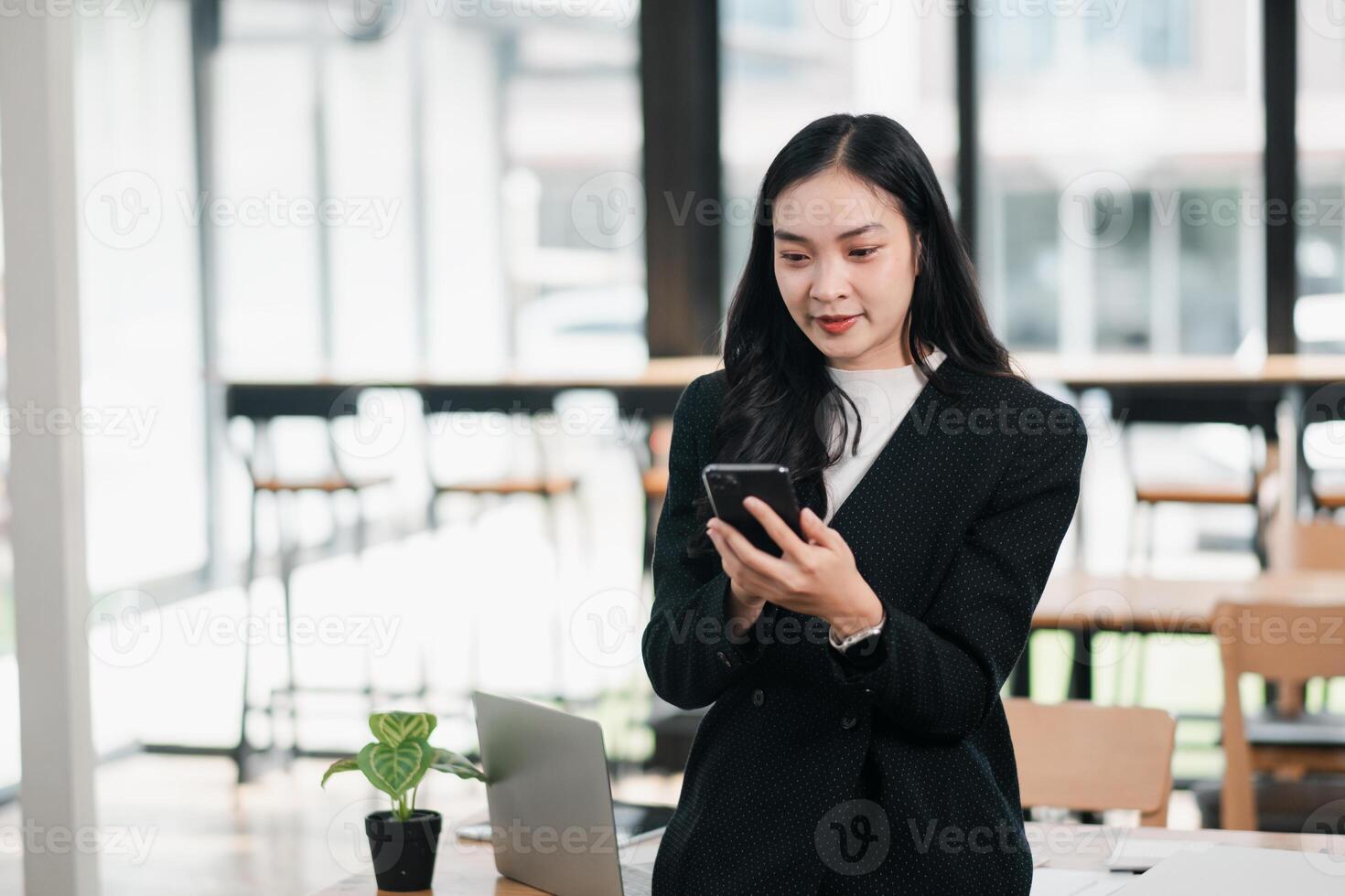 Professional Woman in Modern Office Environment Using Smartphone for Business Communication and Networking photo