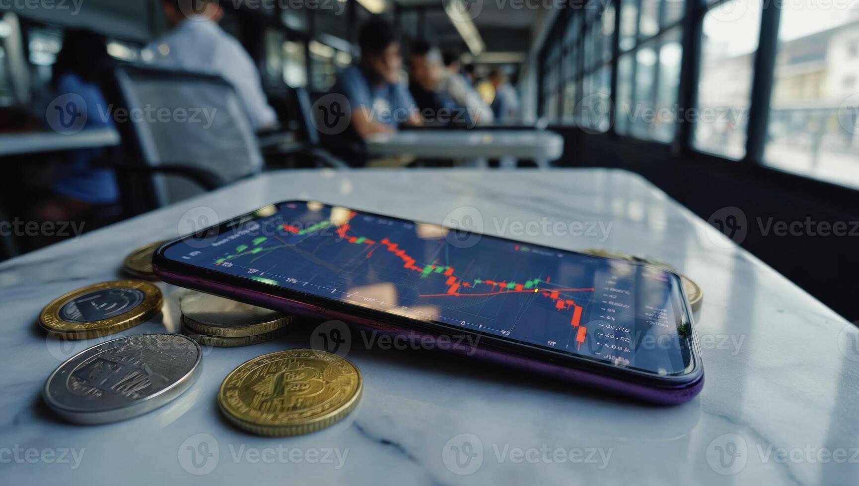 Smartphone showing declining stock market chart with crypto coins on marble table in coworking space photo
