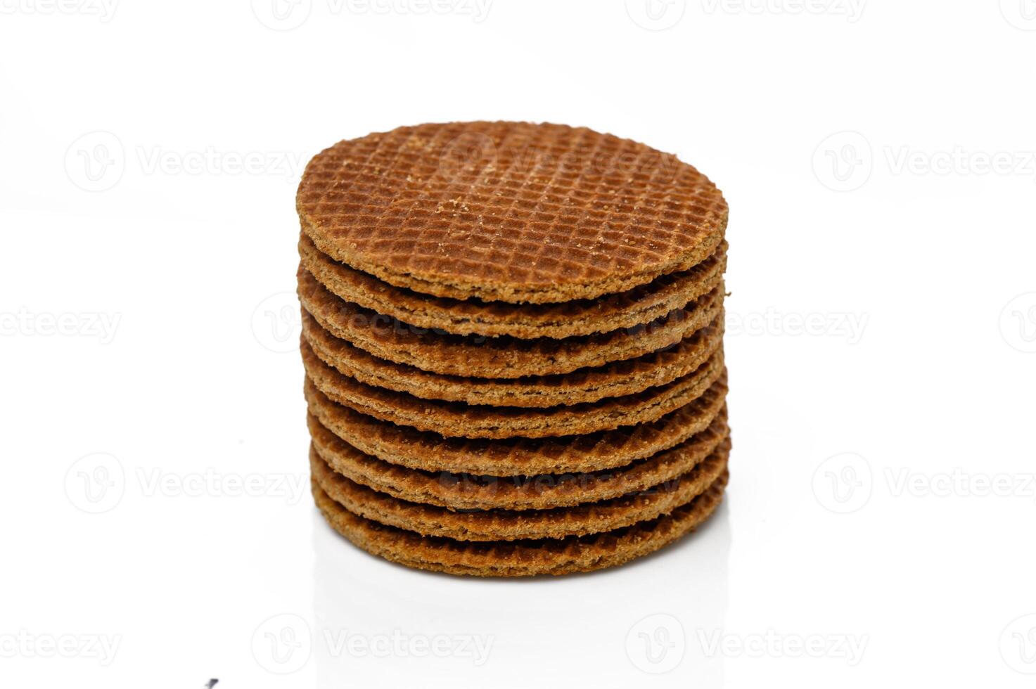 Delicious stacked caramel wafers arranged neatly on a reflective surface in a minimalist setting photo