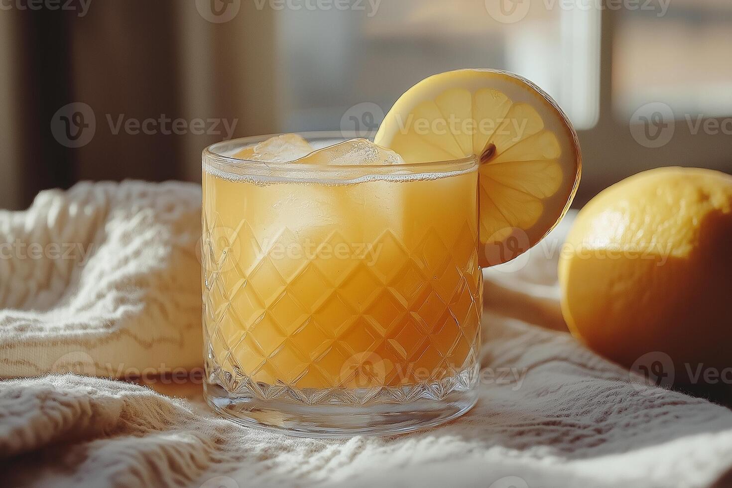 Refreshing citrus drink with ice and lemon, warmly lit by afternoon sunlight indoors. photo
