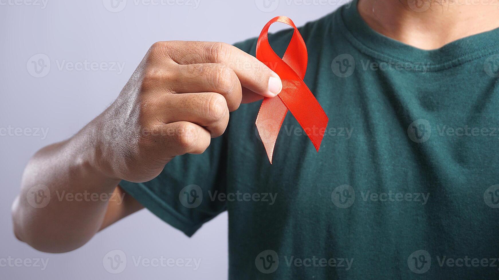 Man Holding Red Ribbon on His Chest Symbolizing Support for People Living With HIV AIDS photo