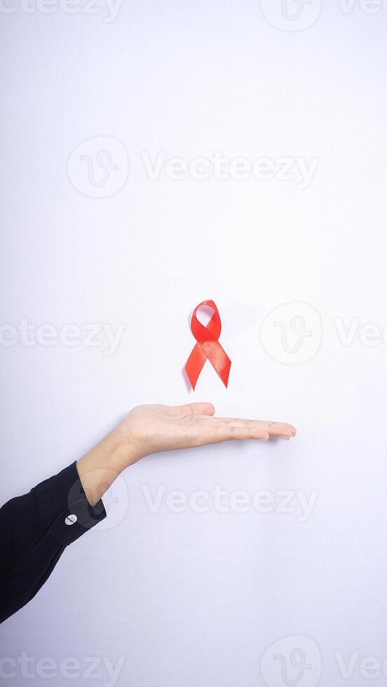 Hand Presenting HIV AIDS Awareness Red Ribbon on White Backgrond photo