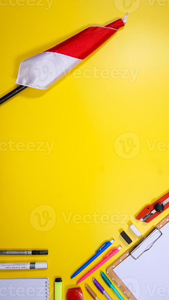School Supplies with Red and White Flag Isolated on Yellow Background with Copy Space photo