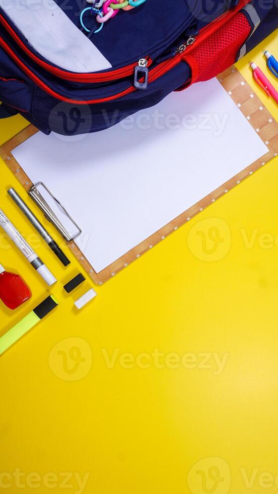 Back to School Concept with Backpack, School Supplies and Copy Space Area Isolated on Yellow Background photo