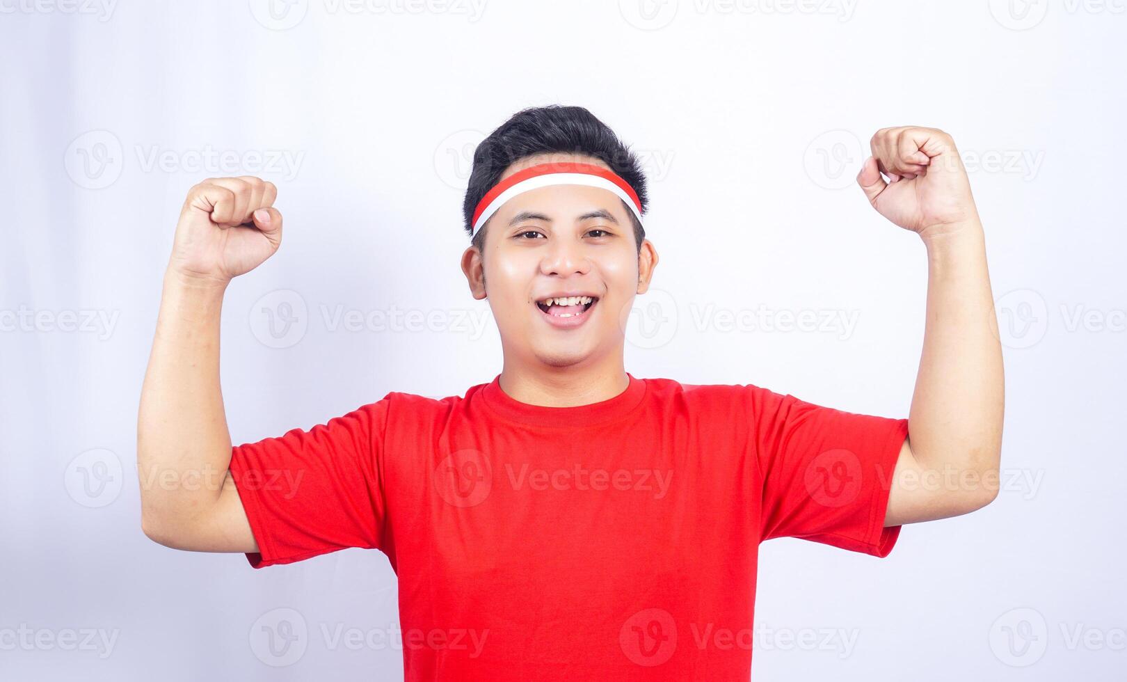 Happy Young Asian Man Clenched Fist Celebrating Independence Day of Indonesia Isolated on White Background photo