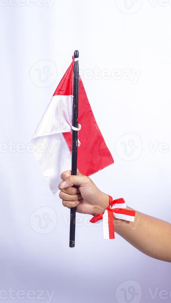Man's Hand Clenched Hand with Red and White Ribbons on His Wrist photo