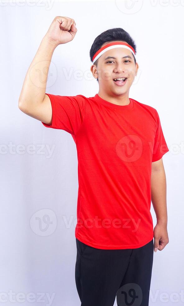 Young Indonesian Man Raising Fist to Celebrate Independence Day of Indonesia Isolated on White Background photo
