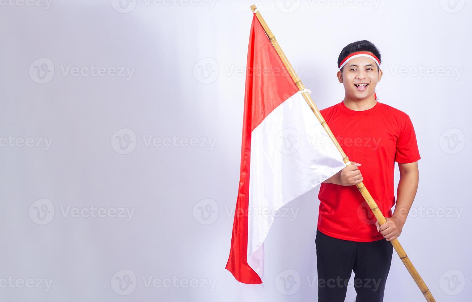 Excited Indonesian Young Man Holding Red and White Indonesia National Flag photo