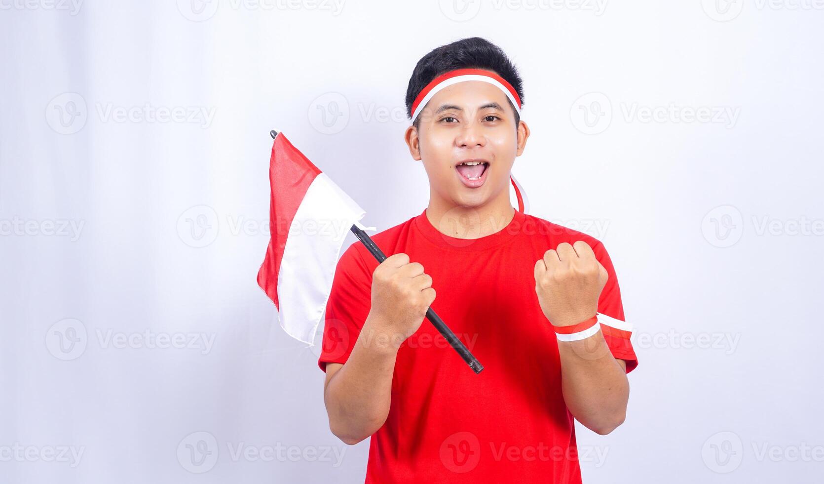 Handsome Indonesian Young Man Celebrate Indonesian Independence Day on 17 August by Holding the Indonesian Flag photo