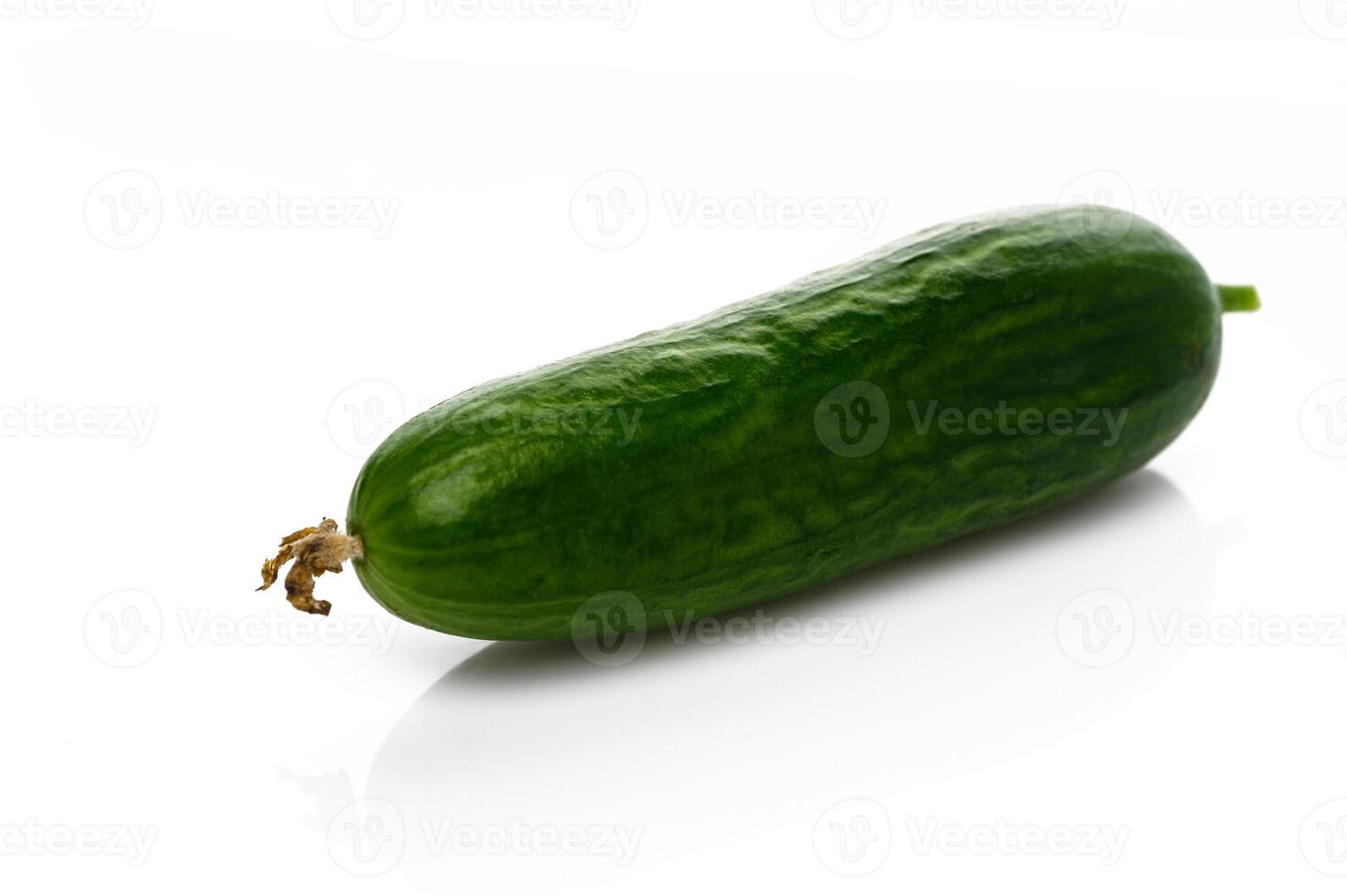 Fresh cucumber showcasing vibrant green color on white surface in a minimalist setting photo