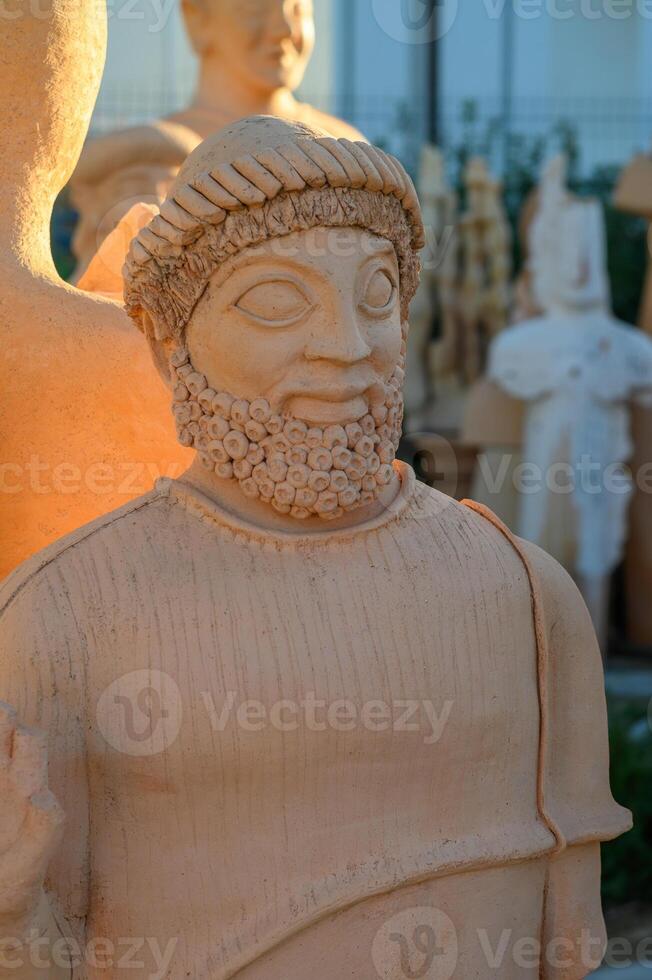 Ancient sculpture with intricate details captured during golden hour in a serene outdoor gallery photo
