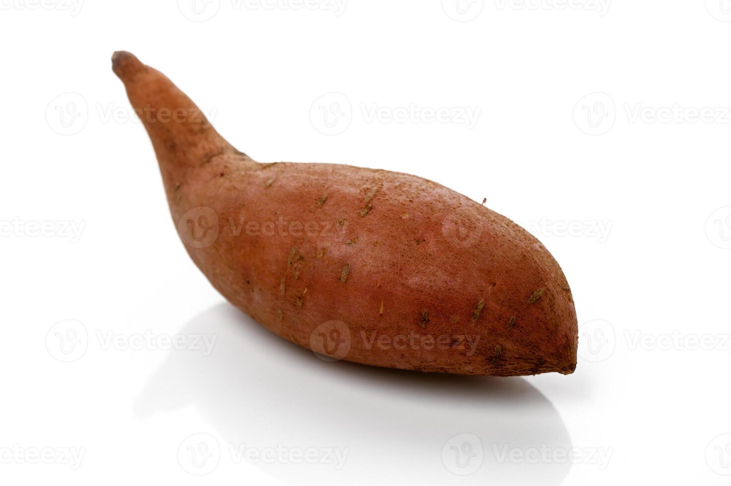 Unique sweet potato resting on a white surface, showcasing its natural curves and earthy texture under soft light photo