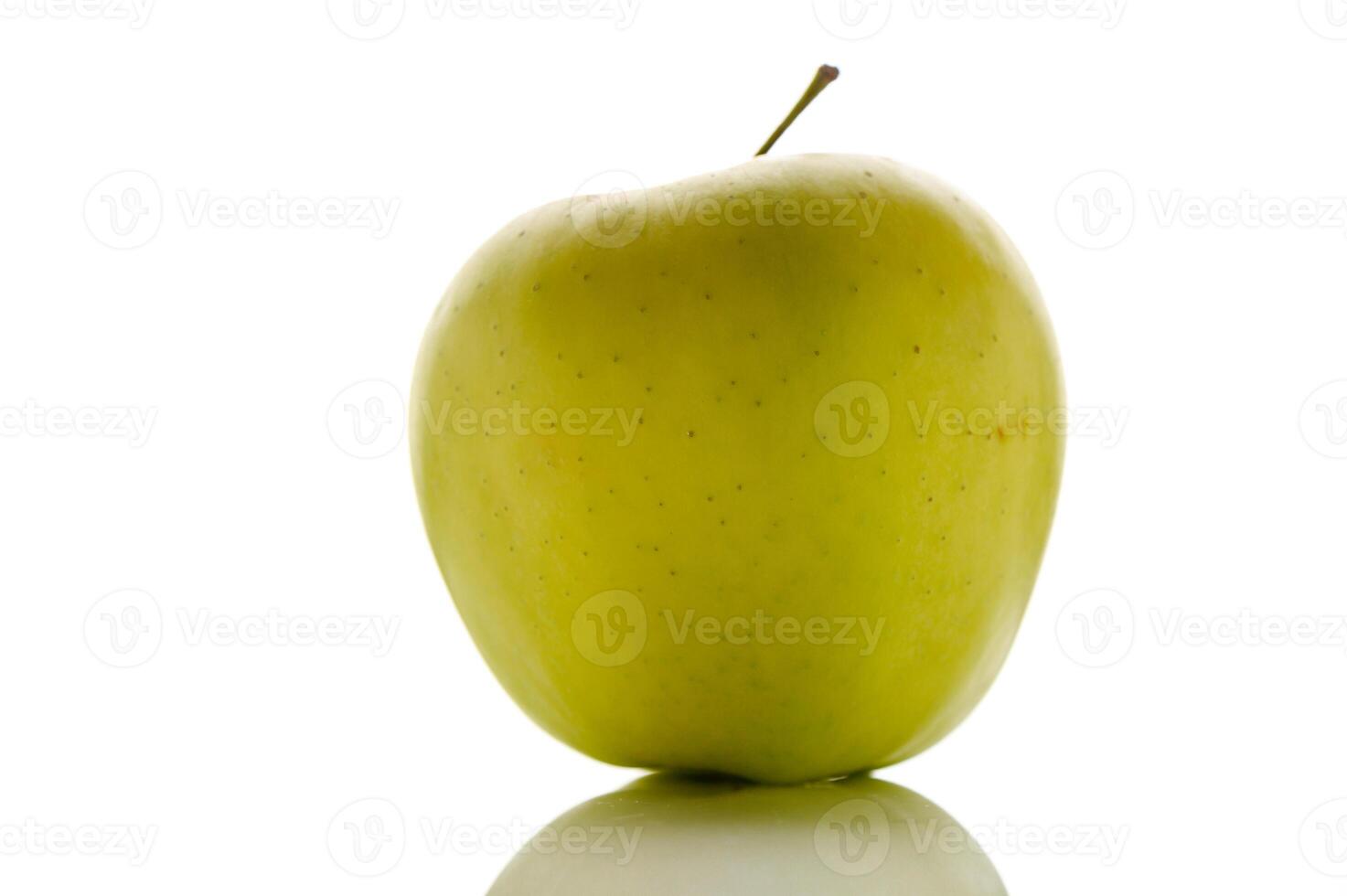 Fresh green apple sits elegantly on a reflective surface, showcasing its vibrant color and smooth texture photo
