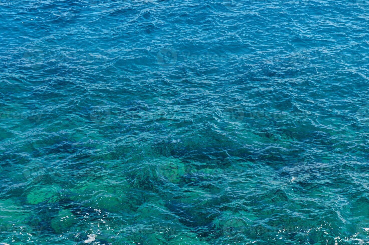 The shimmering turquoise waves of a tranquil ocean on a sunny day. photo
