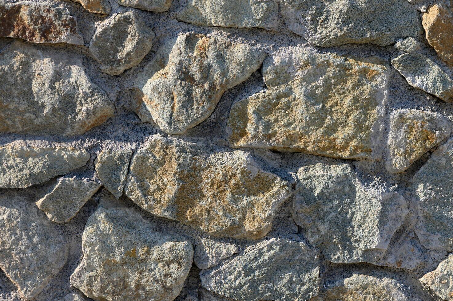 Rustic charm of a weathered stone wall in the heart of a countryside landscape under bright sunlight photo