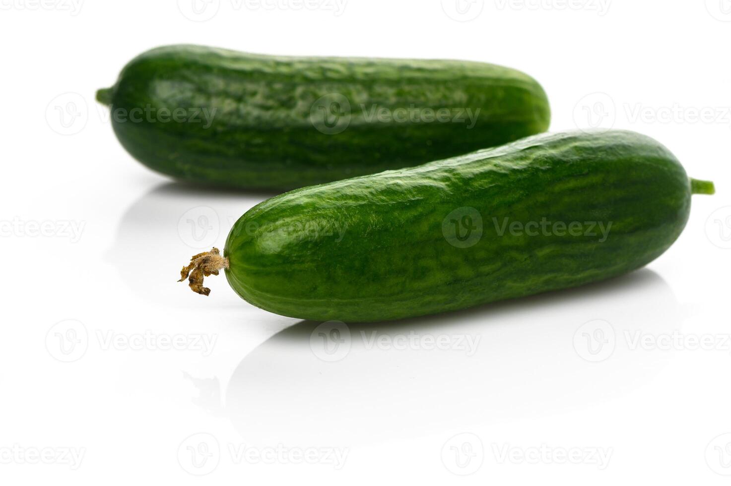 Fresh cucumbers glistening with water droplets on a white background create a vibrant visual of healthy eating photo