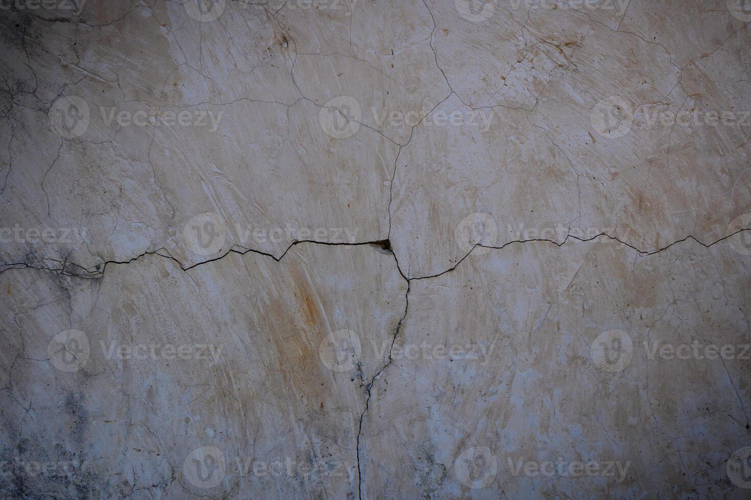 Cracked plaster wall revealing signs of wear and age in a sunlit interior space photo
