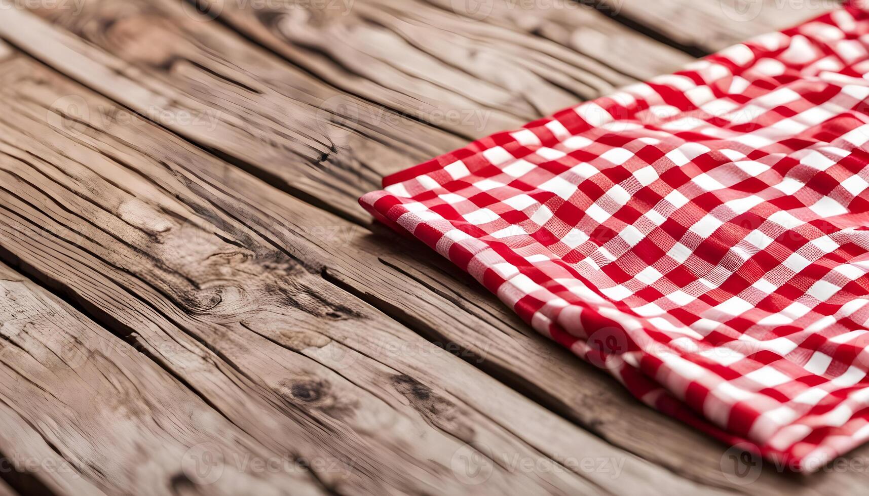 Red checkered tablecloth on wooden table photo