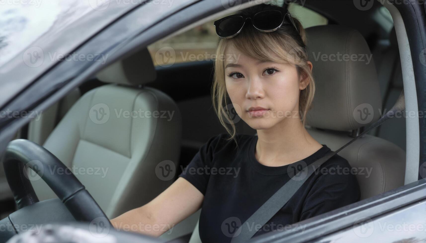 A woman in a car looking at the camera photo