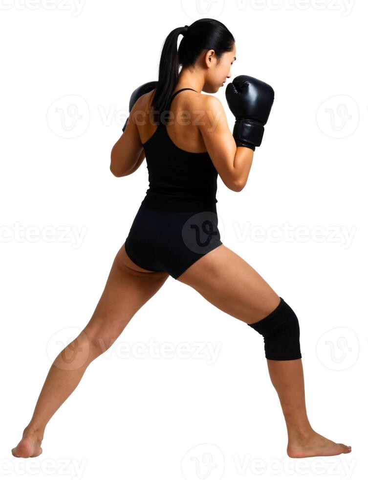 A woman in black boxing gear is doing a kick photo