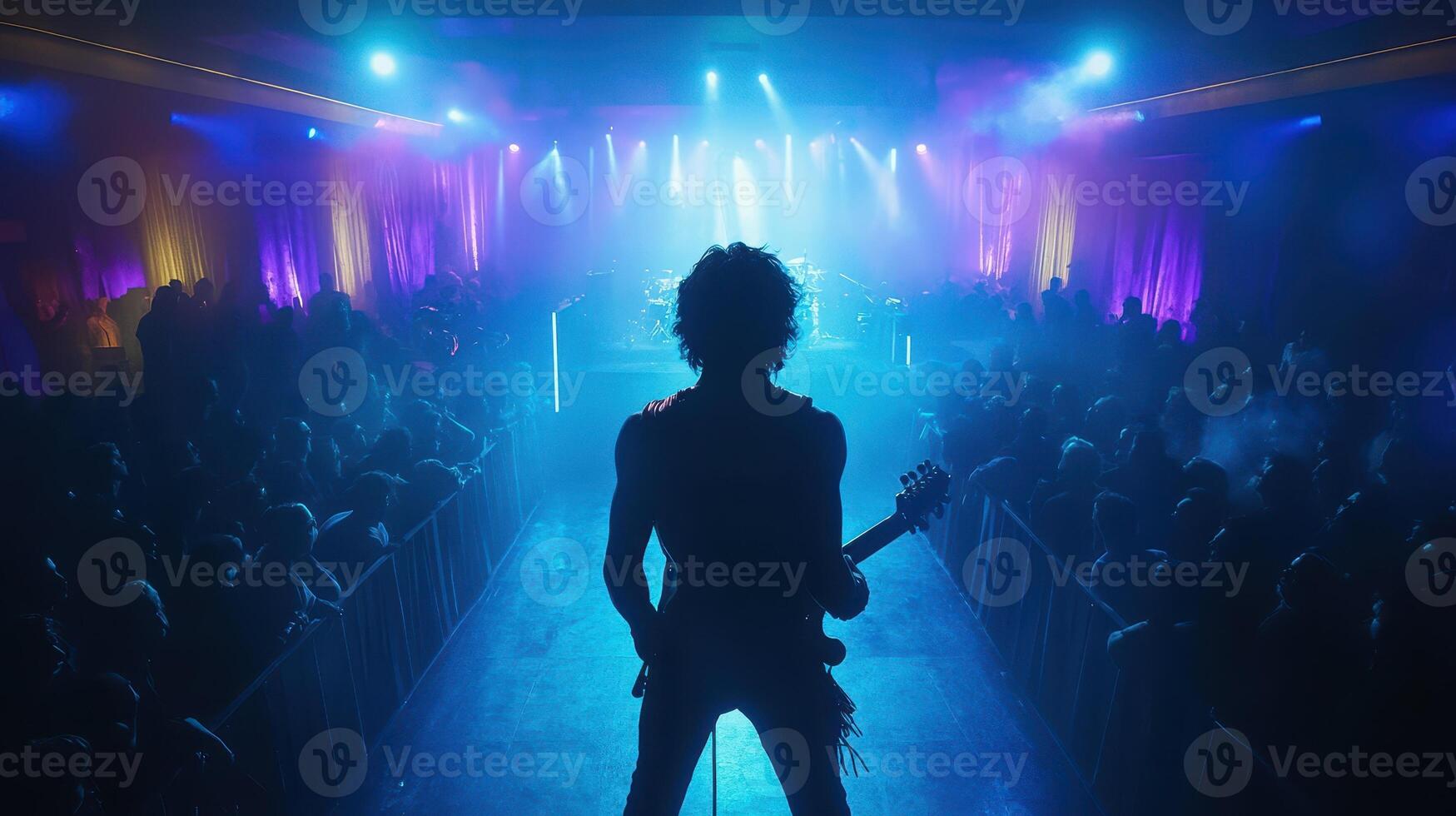 Silhouette of a Guitarist on Stage During a Rock Concert with a Crowd photo