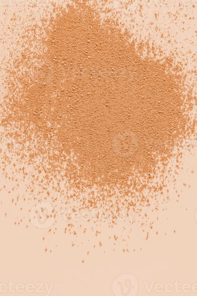 A sample of dry loose powder in a natural tone on a beige background. top view. A copy space. A layout to advertise the texture of the product. photo