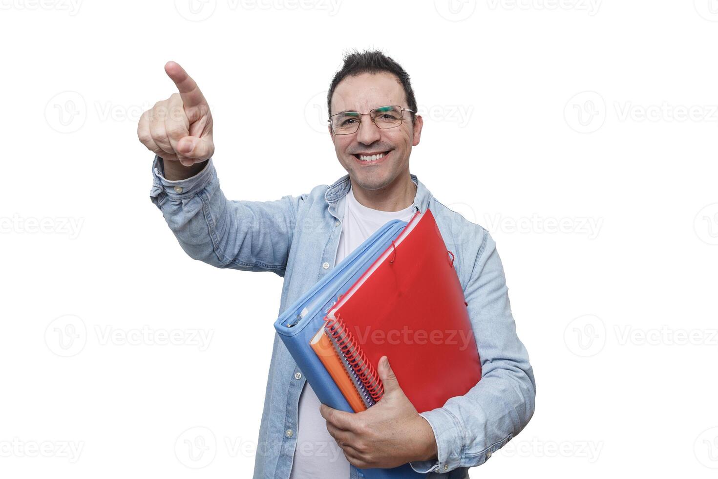 A man smiling and pointing while holding colorful folders in a bright environment. photo