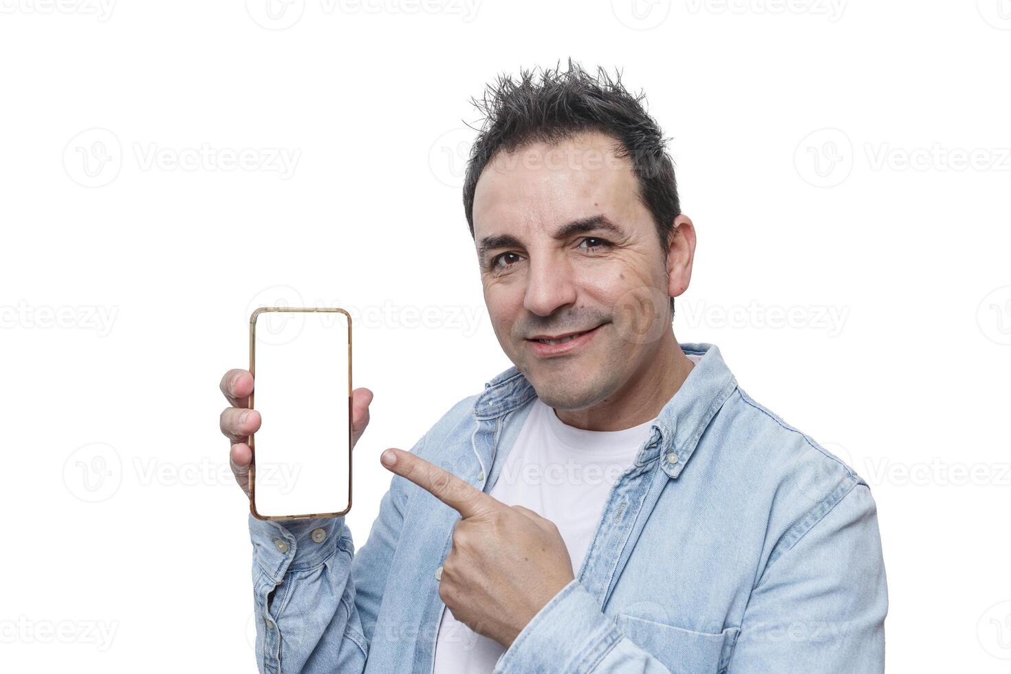 Man points at smartphone with a blank screen while smiling in a bright, neutral setting photo