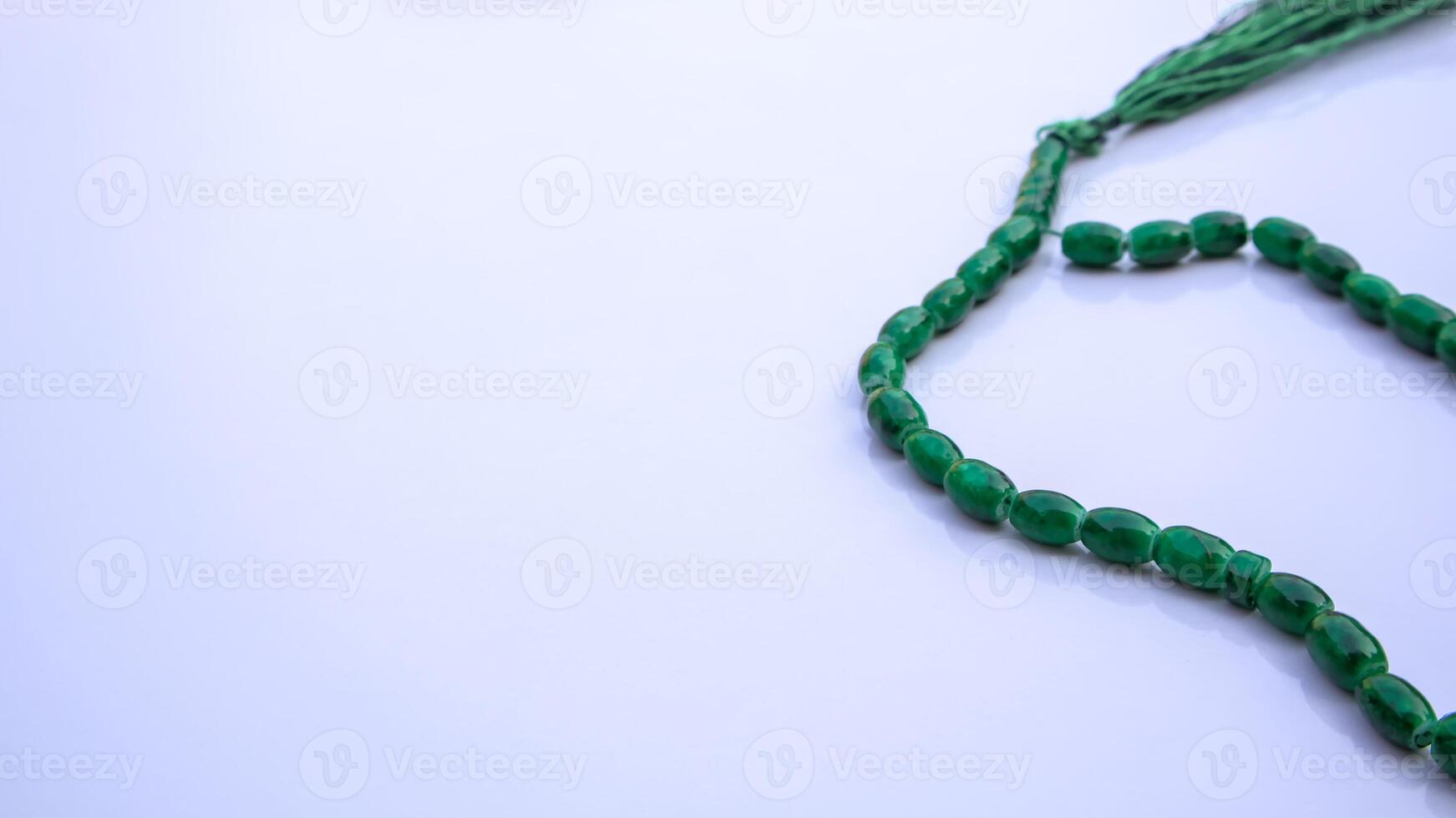 Islamic Prayer Beads, Green Tasbeeh, Misbaha, Rosary on White Background with Copy Space photo