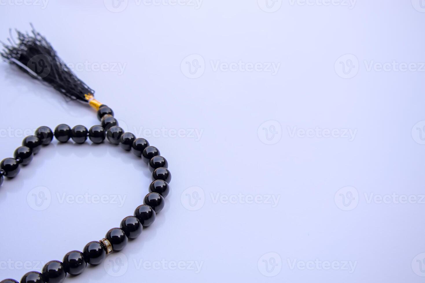 Islamic Black Tasbeeh Prayer Beads, Misbaha on White Background with Copy Space, Close-Up photo