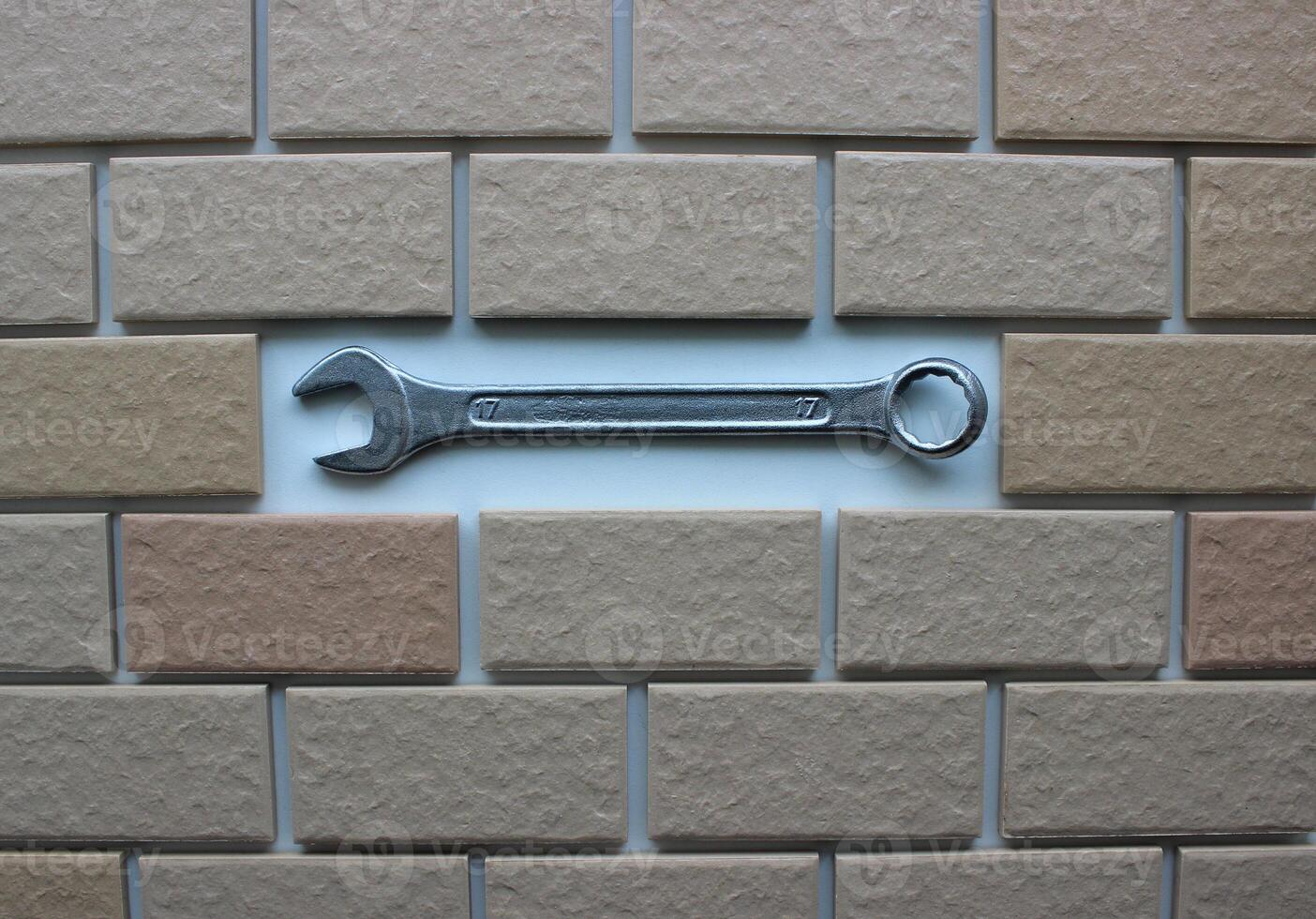 Steel Spanner In Compartment Inside Tiles Brickwork Top View. Stock Photo For DIY Repair Illustration