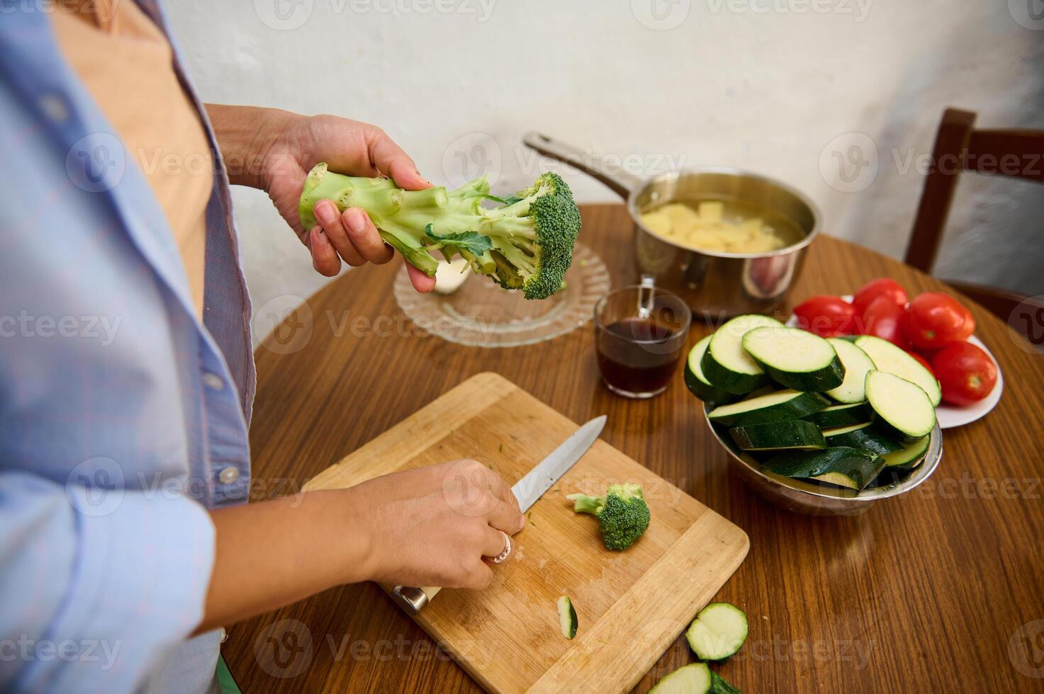 Person preparing fresh vegetables in a cozy kitchen for a healthy meal photo