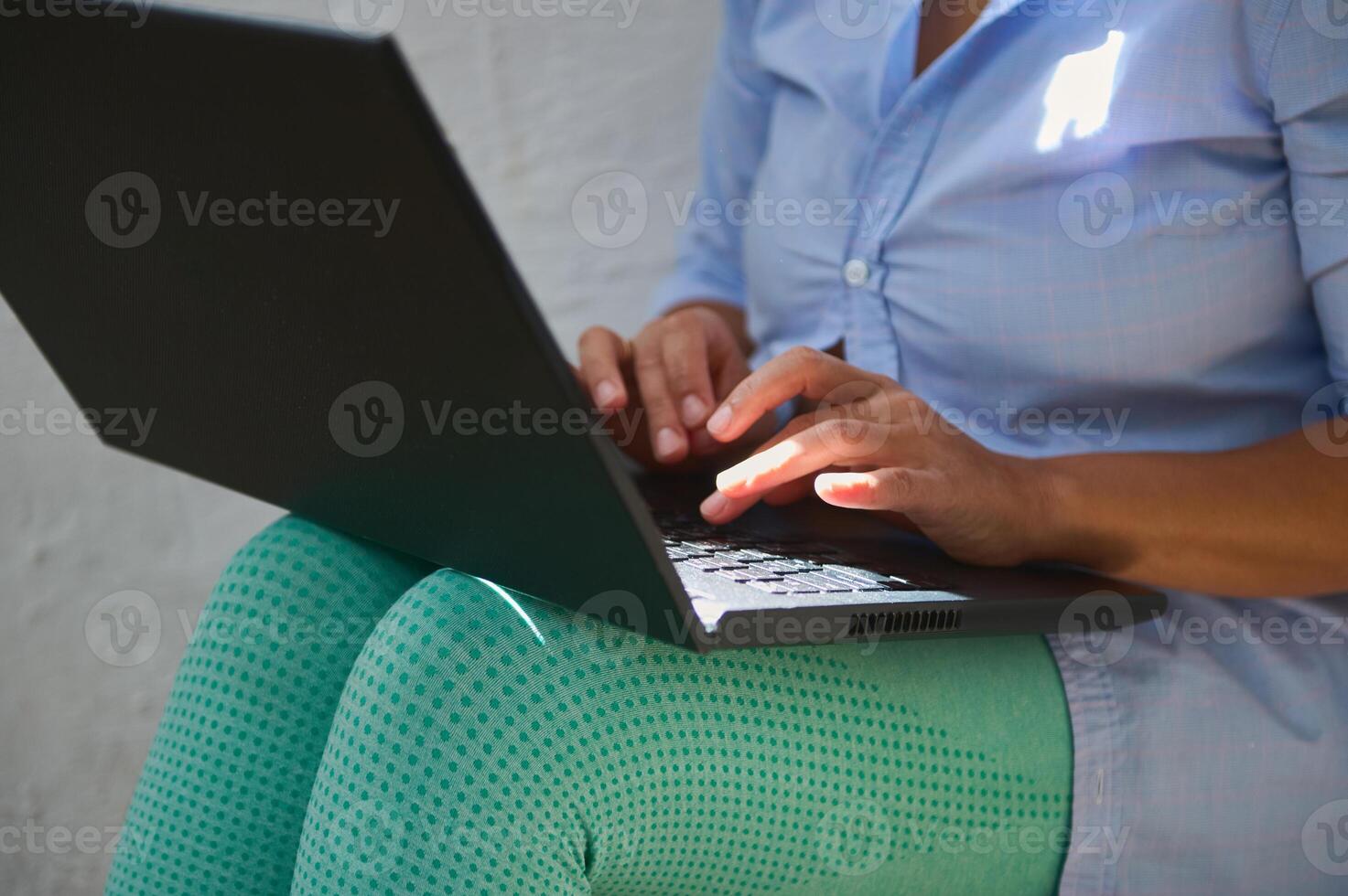 Person Using Laptop on Green-Legged Chair in Natural Daylight photo