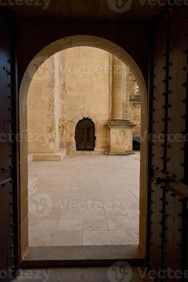 View of a stone courtyard seen through an open traditional arched door photo
