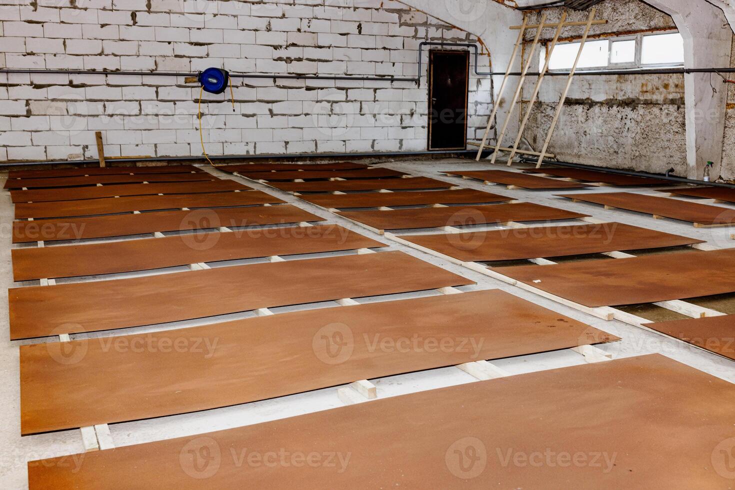 A patchwork of warmth unfolds as multiple brown panels lay scattered on a rustic workshop floor, each surface telling a silent story of craftsmanship and creativity waiting to be unleashed photo
