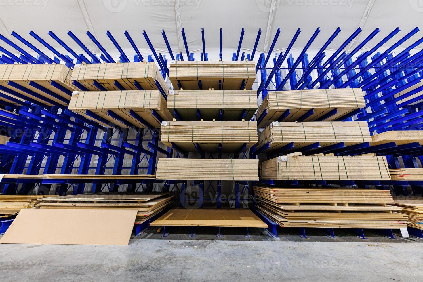Bulk Bliss A Symphony of Blue Racks Supporting Sheets of Natures Canvas in an Expansive Warehouse. photo
