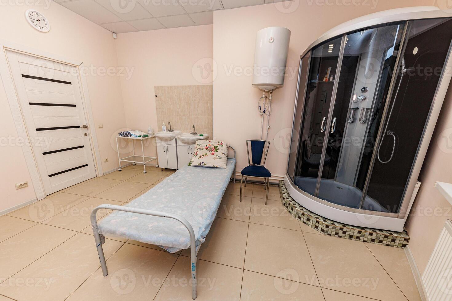 Cozy Retreat A Minimalist Room Featuring a Simple Bed, Sleek Shower Unit, and Inviting Chair, Perfect for Relaxation and Reflection. photo