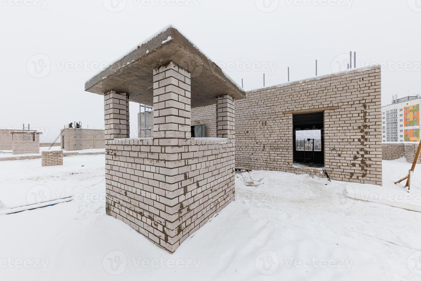 Winters Embrace A Frozen Canvas of Unfinished Dreams, Where Snow-Covered Brick Structures Stand in Anticipation. photo